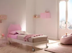 Letto singolo in nobilitato Quarzo con testiera Cat dalle linee pulite laccata Cipria e quattro comode ruote SC102 di Moretti Compact